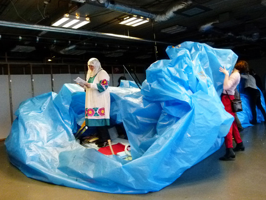 Projects and debris of the workshop are being wrapped up in blue plastic.