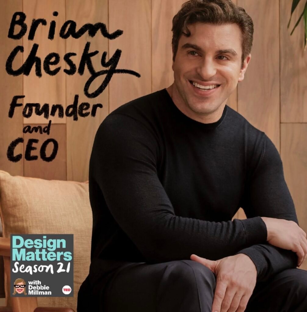 A white man in a black long sleeved shirt, smiling